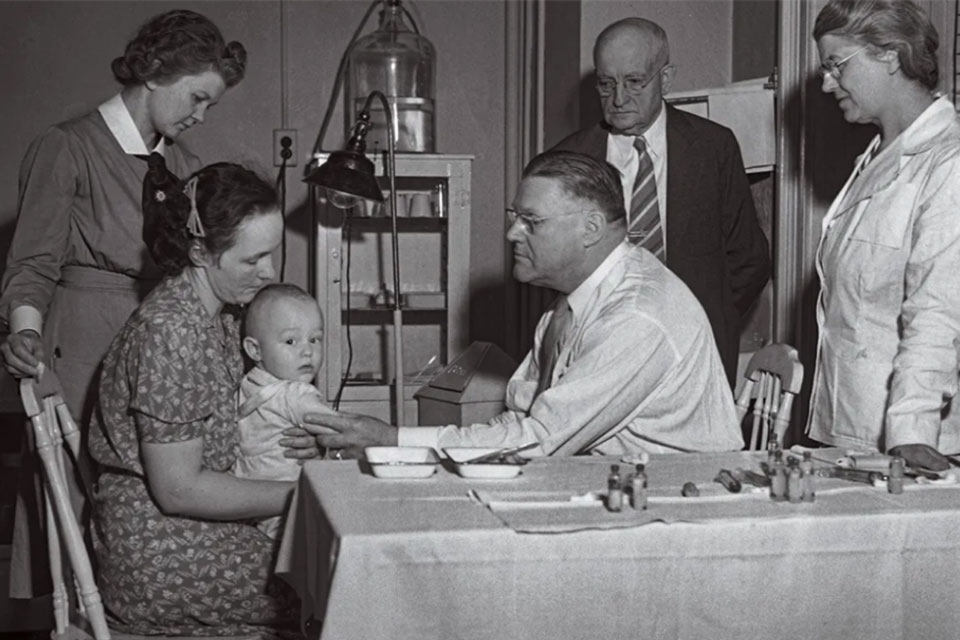 Kendrick, far right, watches a child receive inoculation against pertussis, 1940. Credit: Grand Rapids History Centre, Grand Rapids Library