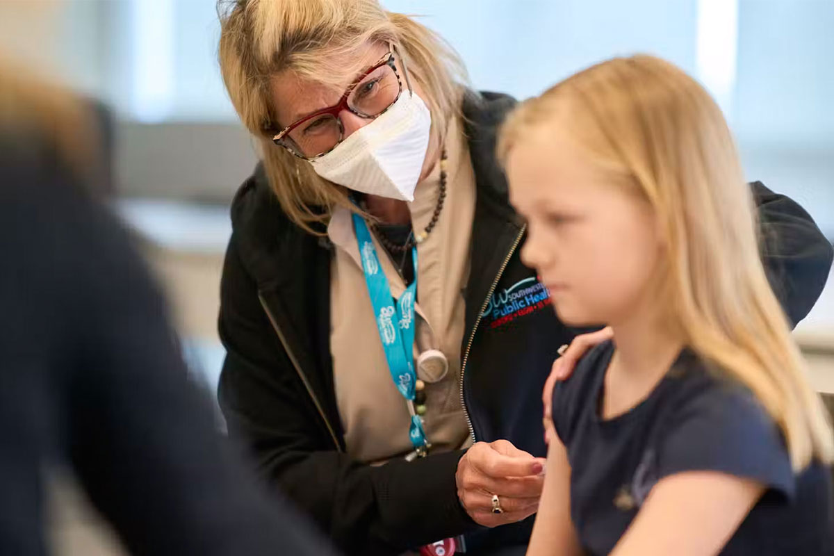 Public health nurse Lauri Bidinot demonstrates how to give a measles shot to a young girl at Southwestern Public Health in St. Thomas, Ont., in March 2025. THE CANADIAN PRESS/Geoff Robins