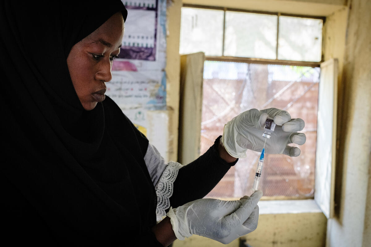 Suad, a vaccination assistant at Umm Al Khair Hospital, preparing a vaccination dose for a child. Umm Al-Khair, Sudan. March 5, 2025.