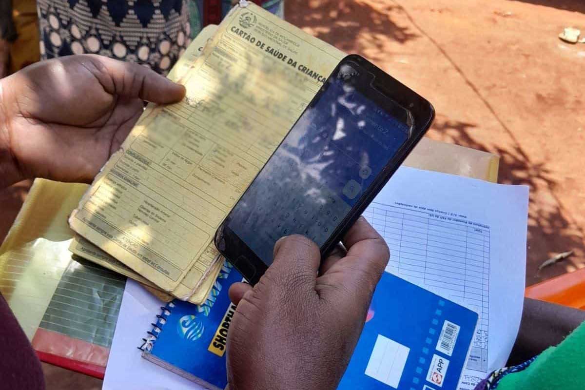 Community health workers enter data from a child’s health information card as part of the mapping phase of the vaccination campaign. (Photo by Saudigitus)