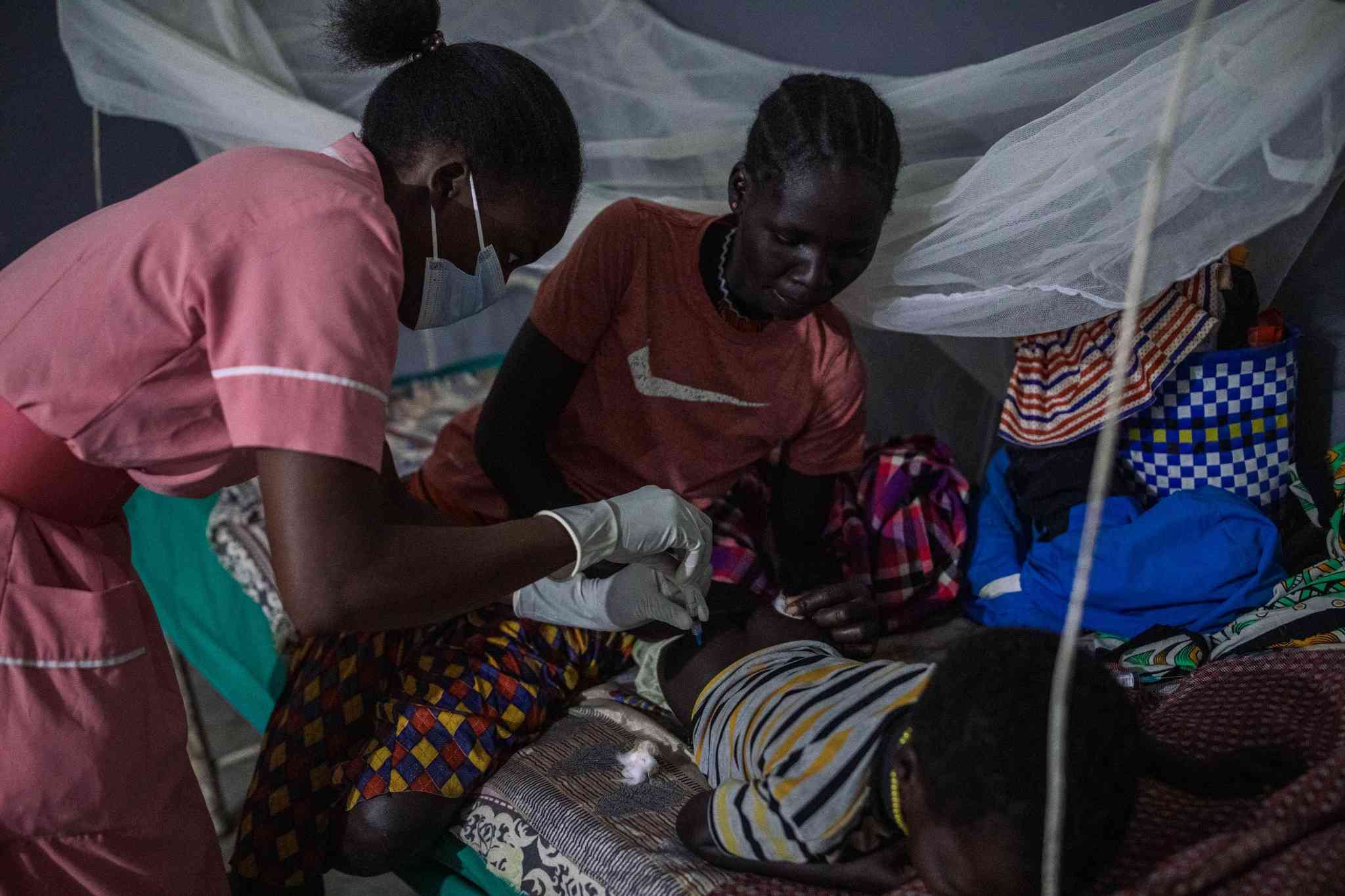 Priscilla Chebjira, the head nurse at Amudat Hospital, and her colleague dispensing SSG:PM treatments at 5am every day.