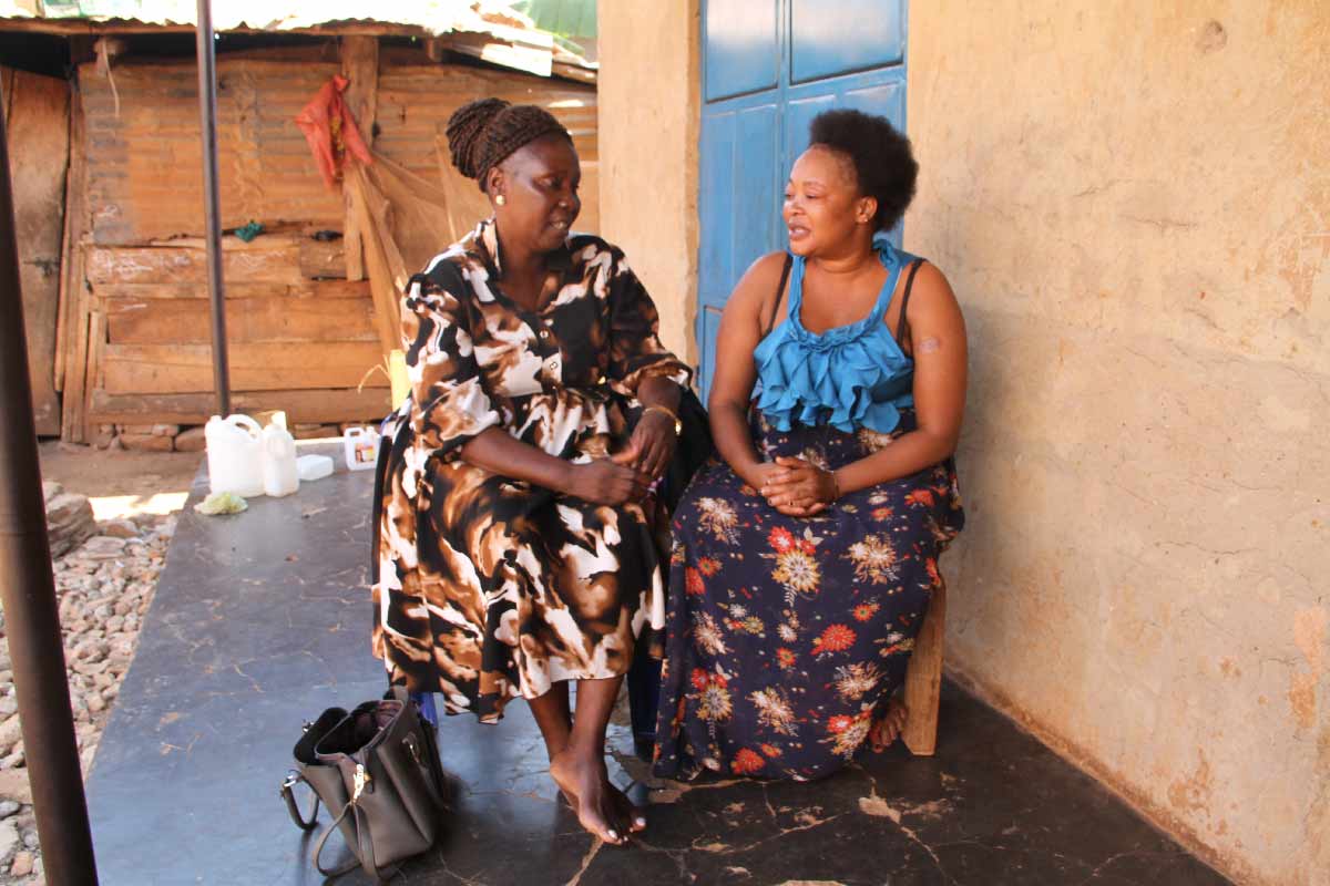 Dorothy Kirunda in her role as a CHW talking with Annet Kizza in Kiyindi town. Credit: James Karuga