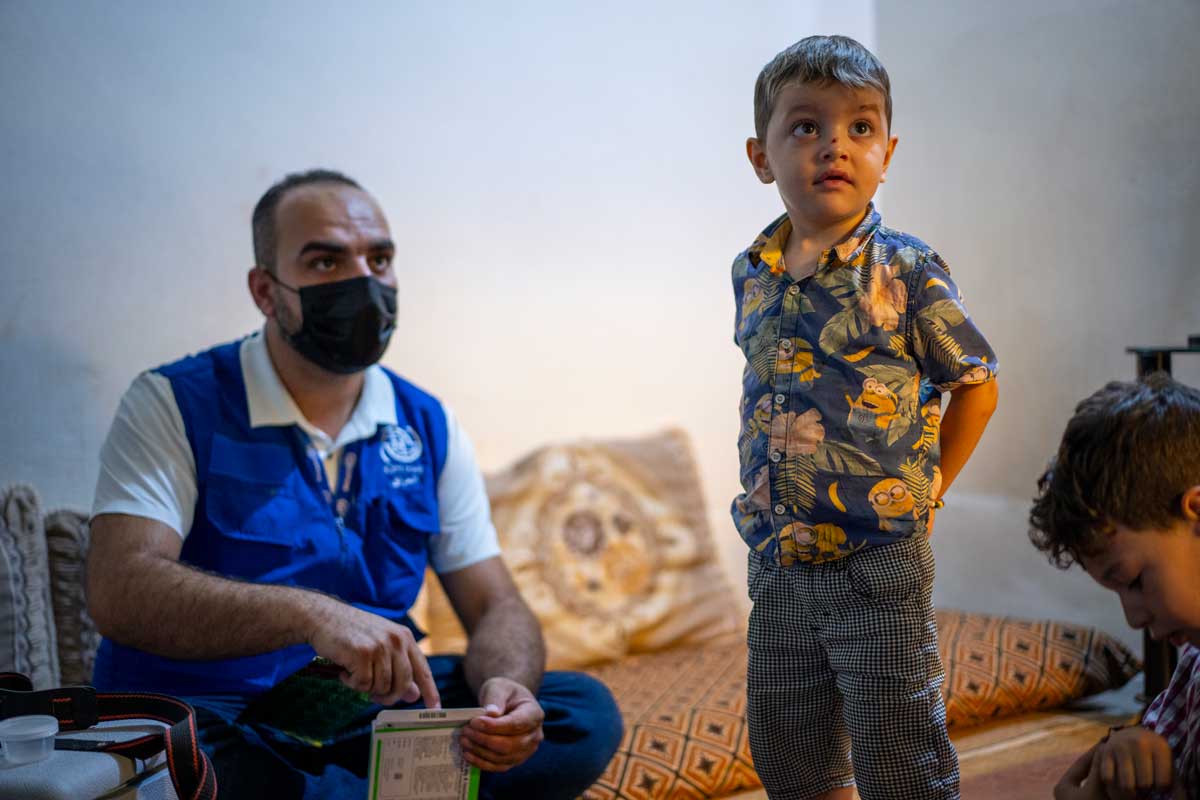 DOTs worker Abdul Qadr visits 4-year-old Adil at his home to help ensure the boy takes his medicine.