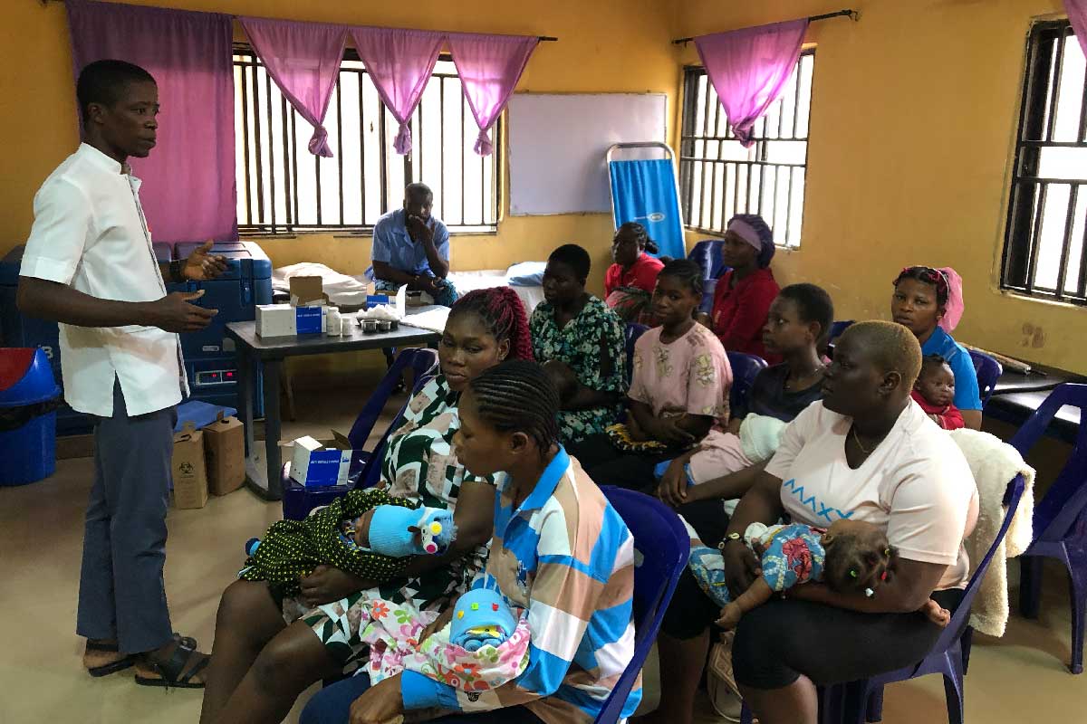 Godwin Anetele urging mothers to allow their babies to take the malaria vaccine. Credit: Ekpali Saint