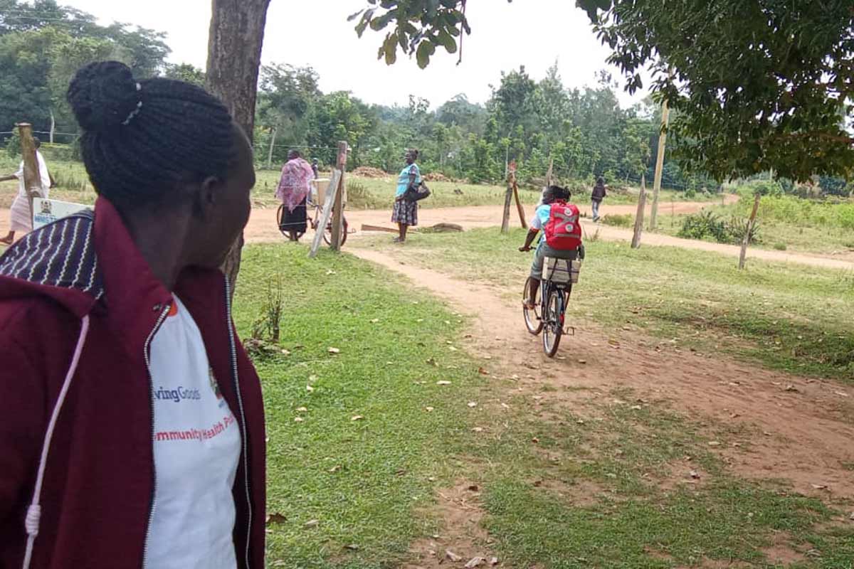Ms Linet Opili, a community health promoter, cycles a bicycle after collecting medical commodities from Akolong Dispensary in Busia, Kenya. Credit: Angeline Anyango.