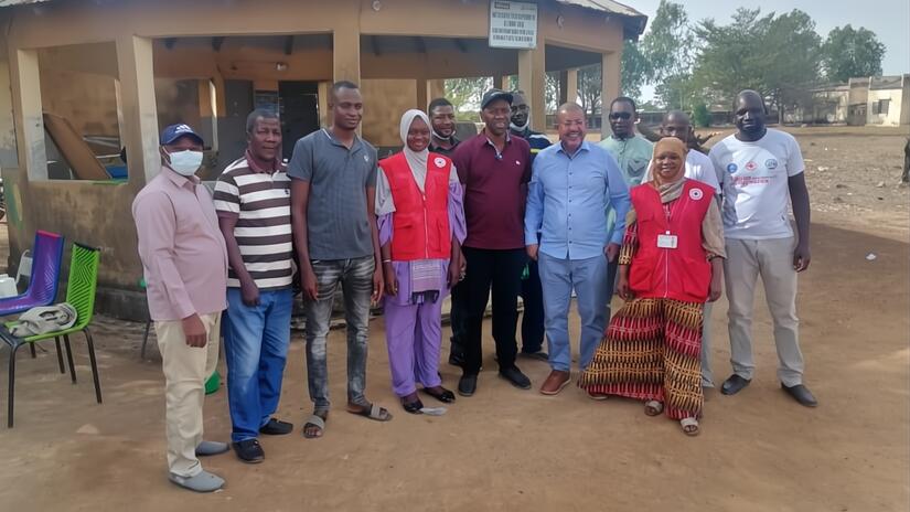 Mali Red Cross, IFRC and local health authority staff stand together at a planning session to discuss how to reach underserved populations with life-saving vaccines. Photo: Mali Red Cross