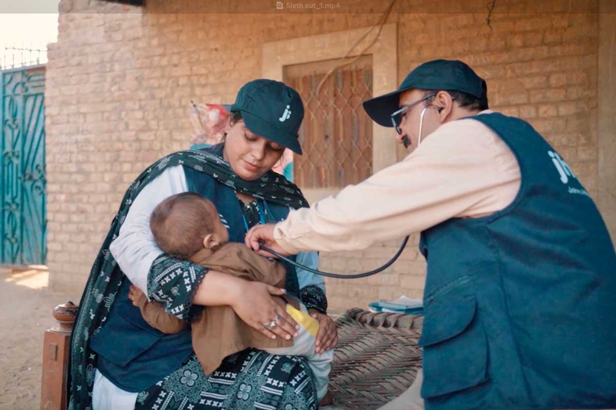Medical practitioners examining a child during health camps set up for underserved communities in Pakistan’s worst flood affected and hard to reach districts. Credit: Jhpiego.
