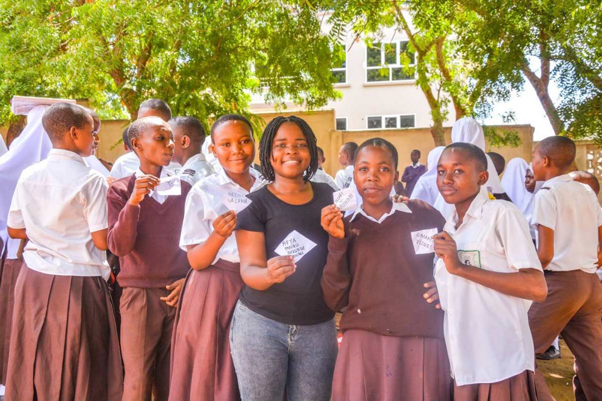 Faustina Goodluck surrounded by students during one of her outreach programs. Goodluck educates communities on preventable diseases, and advocates for better nutrition. Courtesy of Faustina Goodluck