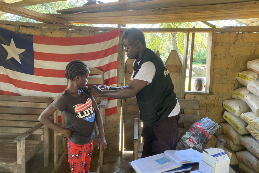 Jerry Karn, a rural vaccinator, administers the HPV vaccine to a nine-year-old during an outreach in Zuoplay, Nimba County. Credit: Tina S. Mehnpaine