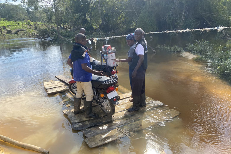 Jerry Karn and others on outreach, crossing a creek on a raft in order to reach far-flung members of the community. Credit: Tina S. Mehnpaine