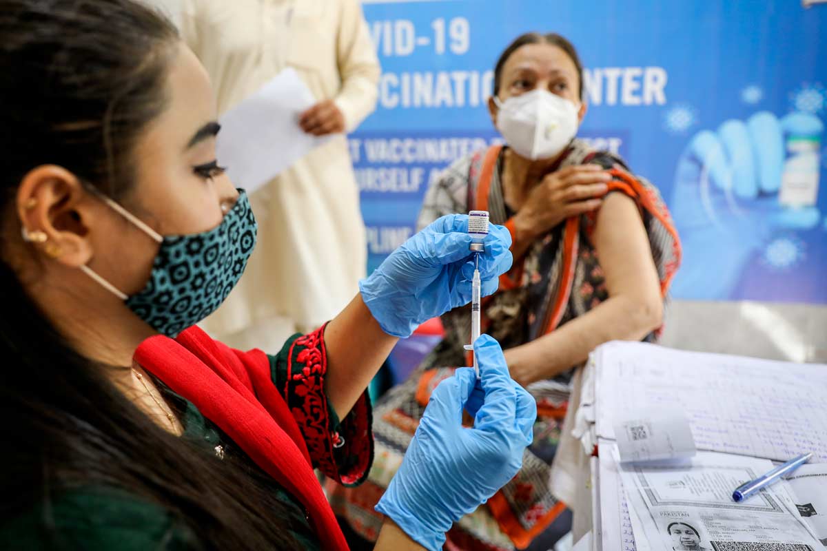 A health worker preparing COVID-19 vaccination for a woman at a government vaccination center in Islamabad, Pakistan. Credit: Gavi/2021/Asad Zaidi