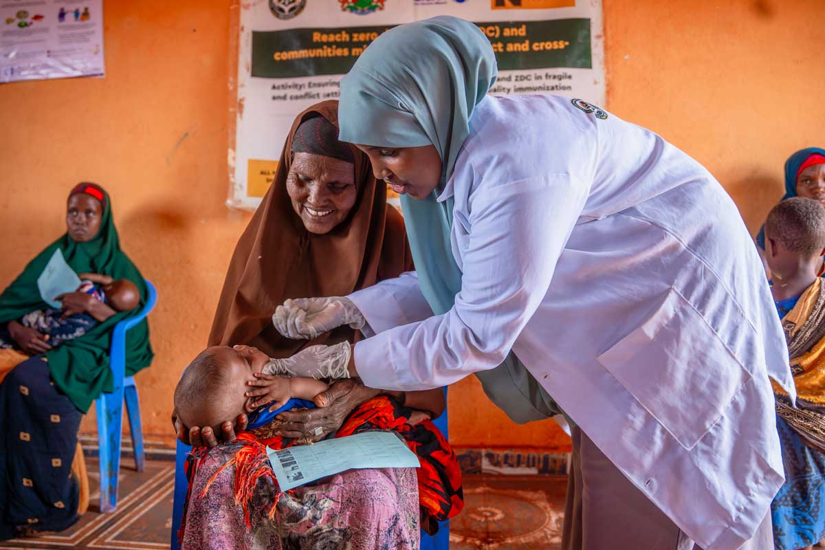 A health worker in Somalia administers an oral dose of vaccine to a child, held by his grandmother. Credit: Gavi/2024/Mohamed Abdihakim Ali