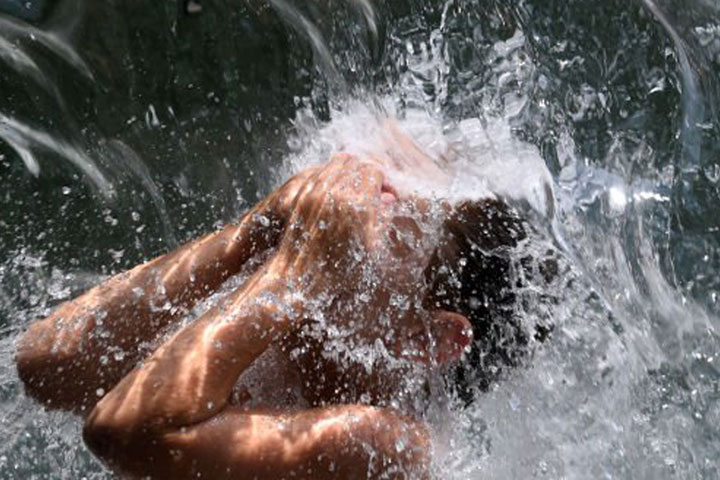 Extreme heat can become lethal quickly. A young man cools off at Washington, D.C.’s Yards Park during a heat wave in 2021. Credit: Olivier Douliery/AFP via Getty Images
