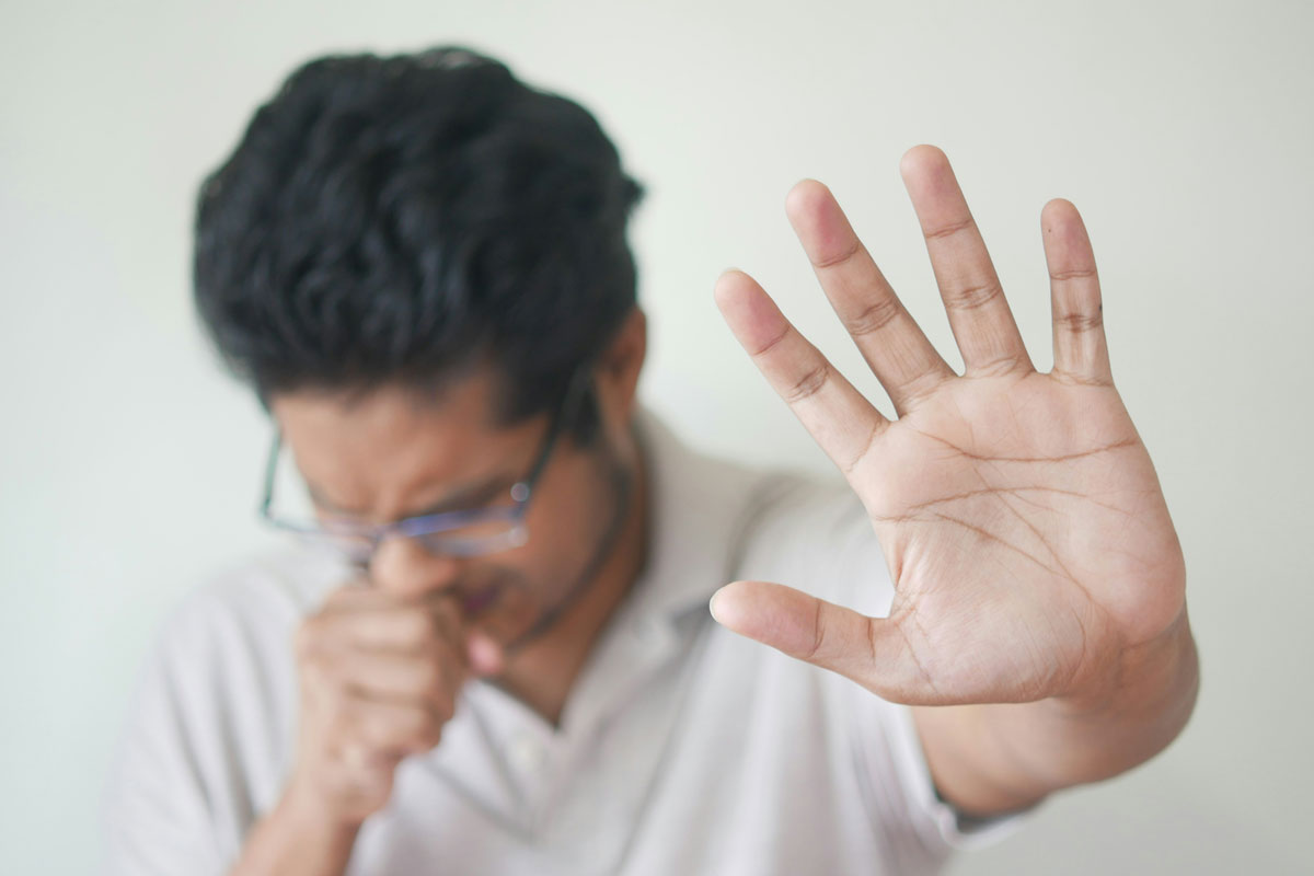 Man coughing with arm outstretched. Credit: Towfiqu barbhuiya/ Unsplash