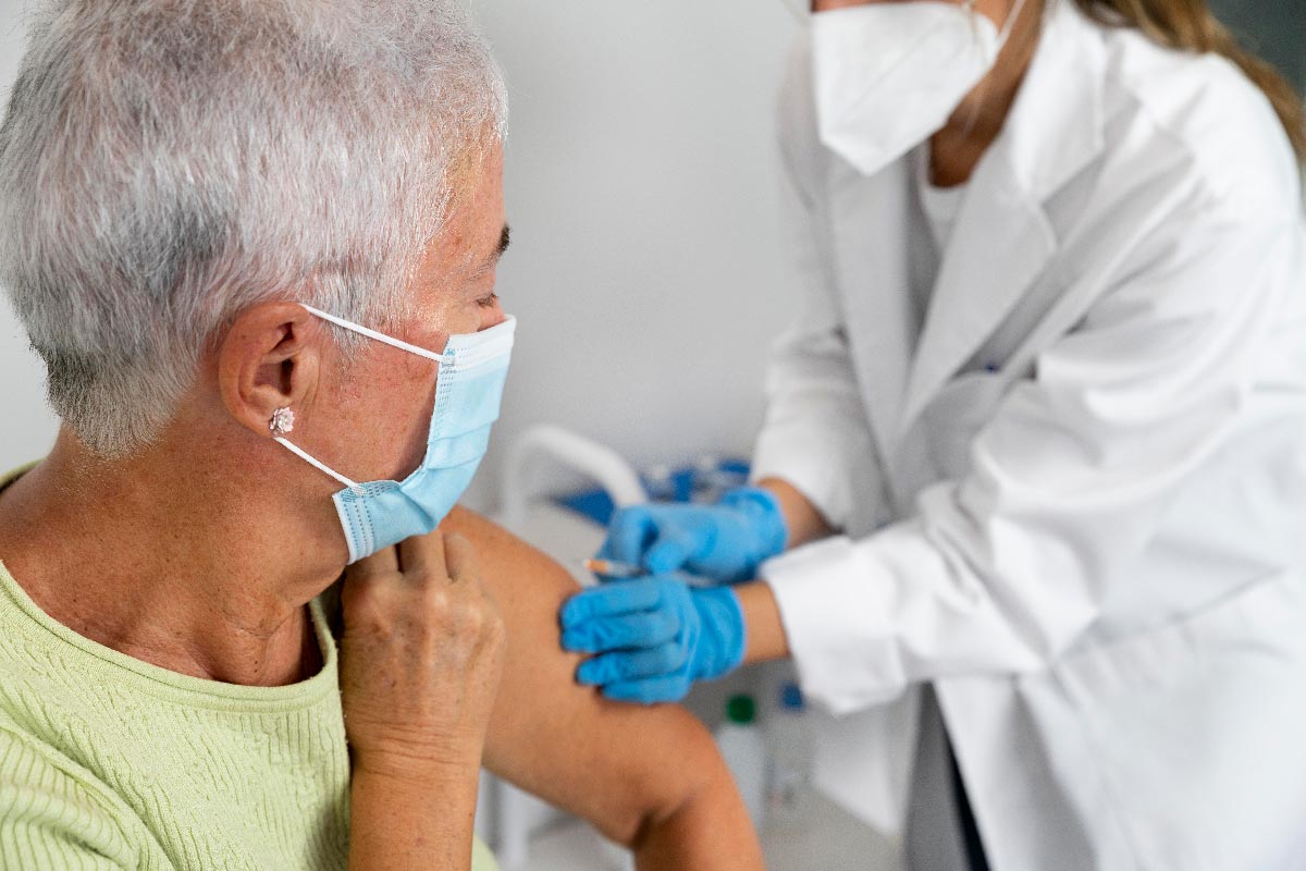 A woman receiving a vaccine from a health worker. Credit: Freepik