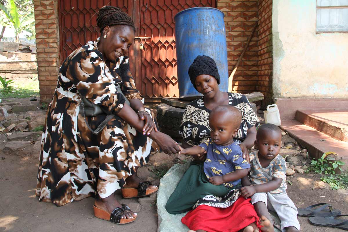 Dorothy Kirunda chats with Aisha Nakabuye, a mother with a child with hydrocephalus at Kiyindi town. Credit: James Karuga