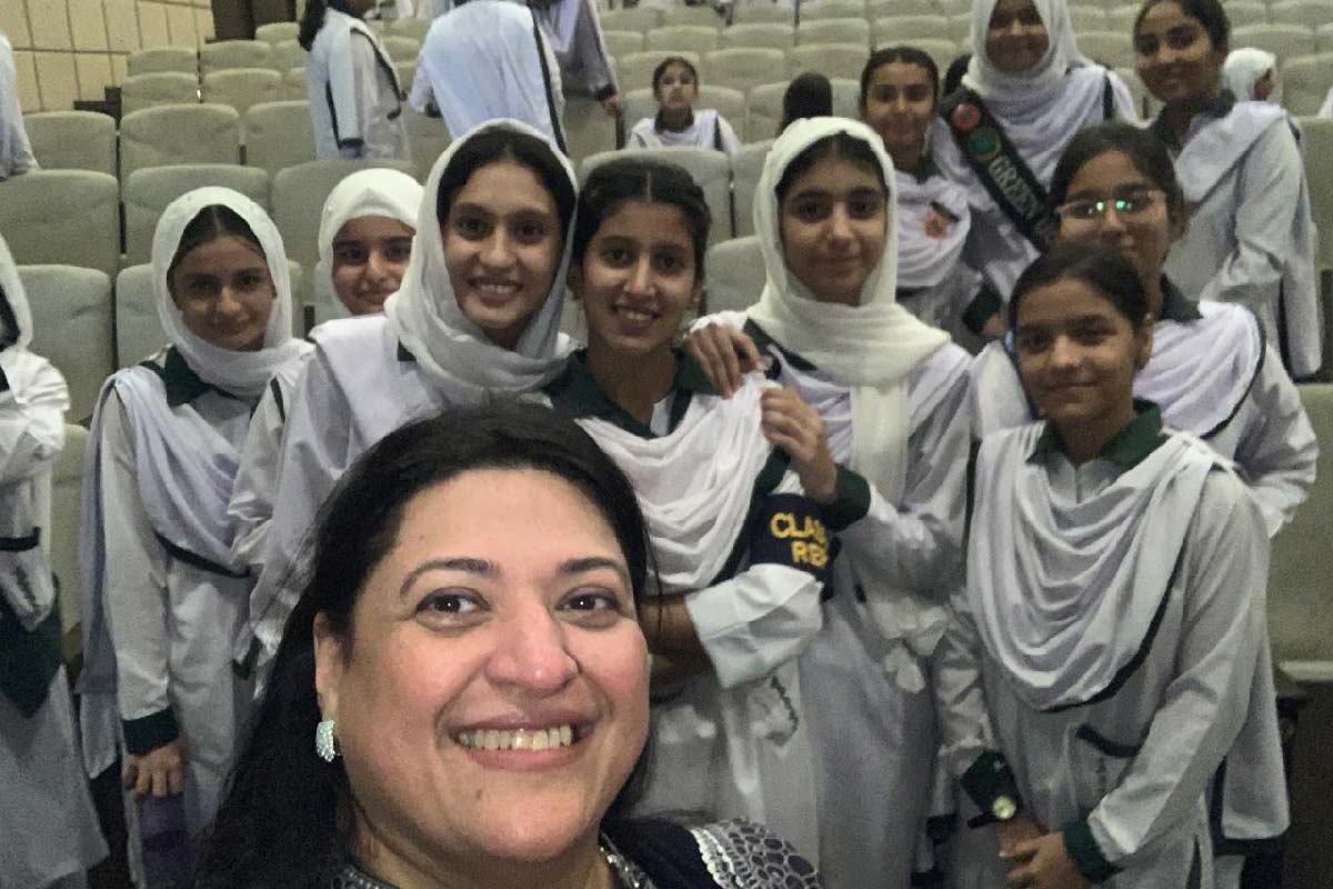 Dr Saima Zubair in front of a group of schoolgirls. Credit: Dr Saima Zubair