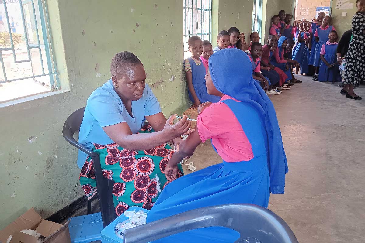 Esther Ndhlovu vaccinating a pupil at Mbayani. Credit: Benson Kunchezera