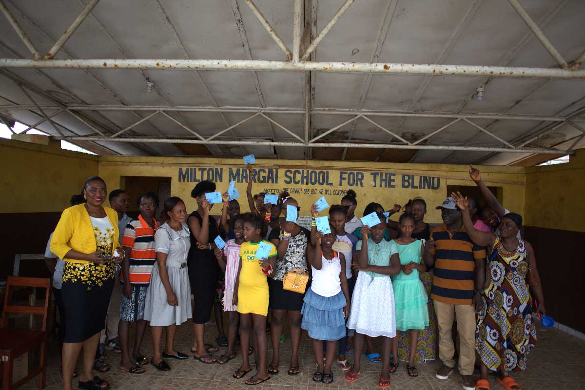 Health workers and pupils of the Milton Margai School for the Blind holding vaccination cards during a HPV vaccination campaign in Freetown. Credit: Saidu Bah