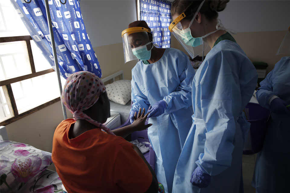 Health workers check the hands of an mpox patient at a treatment centre in Freetown. Credit: Saidu Bah