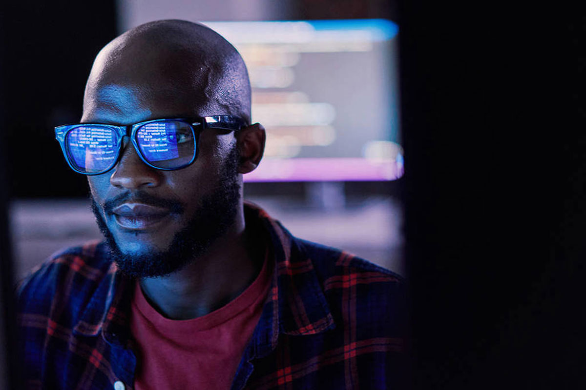 A man sits in front of a computer screen. Credit: pixdeluxe/Getty Images
