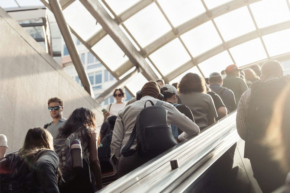 Morning commuters riding an escalator. Credit: Connor Gan