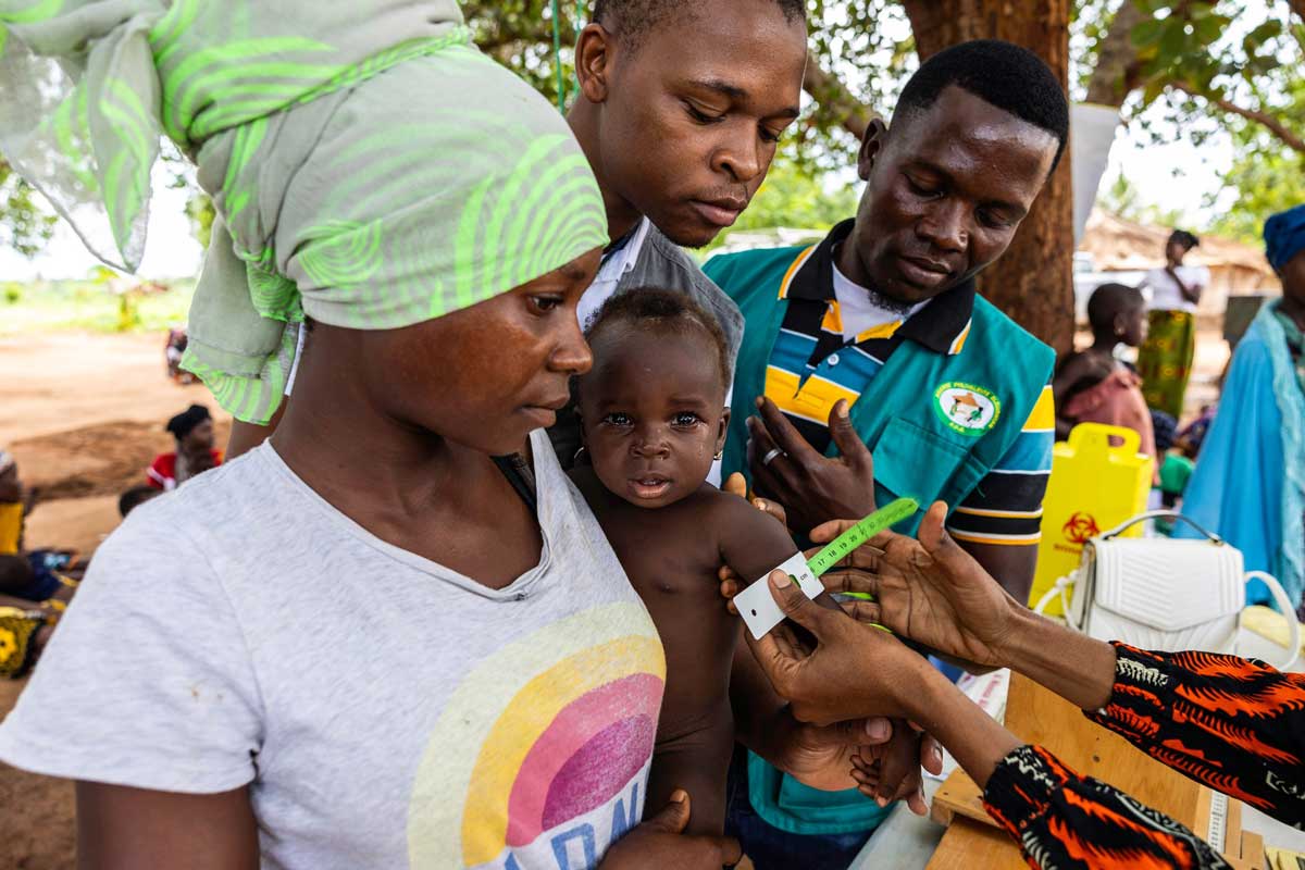 Une mère et son enfant entourés de professionnels de santé lors d’une séance de vaccination au Mozambique. Crédit : Ministère de la Santé du Mozambique.