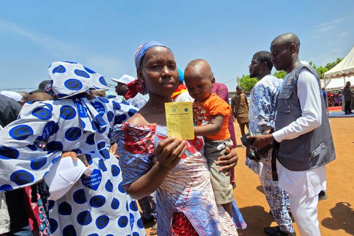 A mother shows her child’s vaccination card after the administration of the malaria vaccine, during the launch ceremony in Kalaban-Coro, on the outskirts of Bamako. Credit: Aliou Diallo