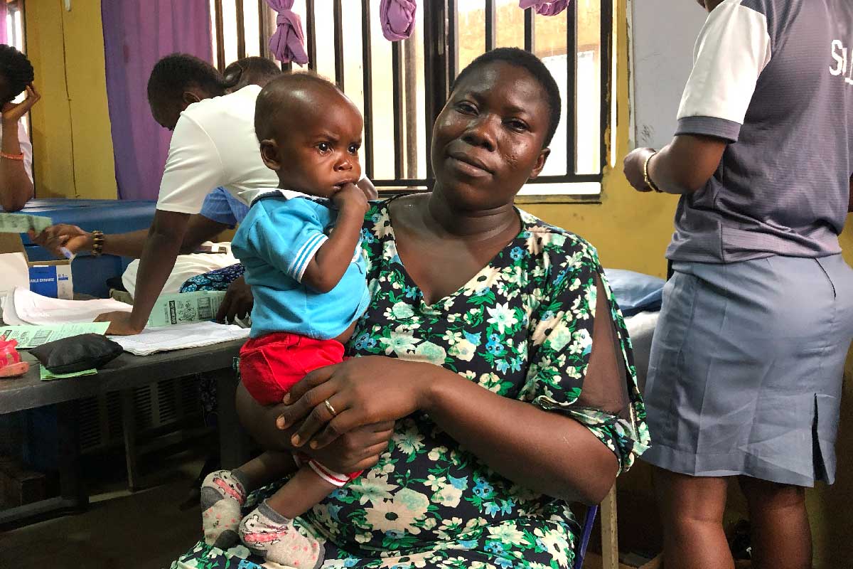 Sandra David holding her child. Credit: Divinewealth