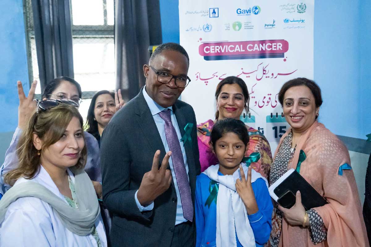 Gavi Chief Country Delivery Officer Thabani Maphosa, flashing a victory sign along with a Health Department official and an adolescent girl who received the HPV vaccine at a government run school in Islamabad. Credit: Federal Directorate of Immunization