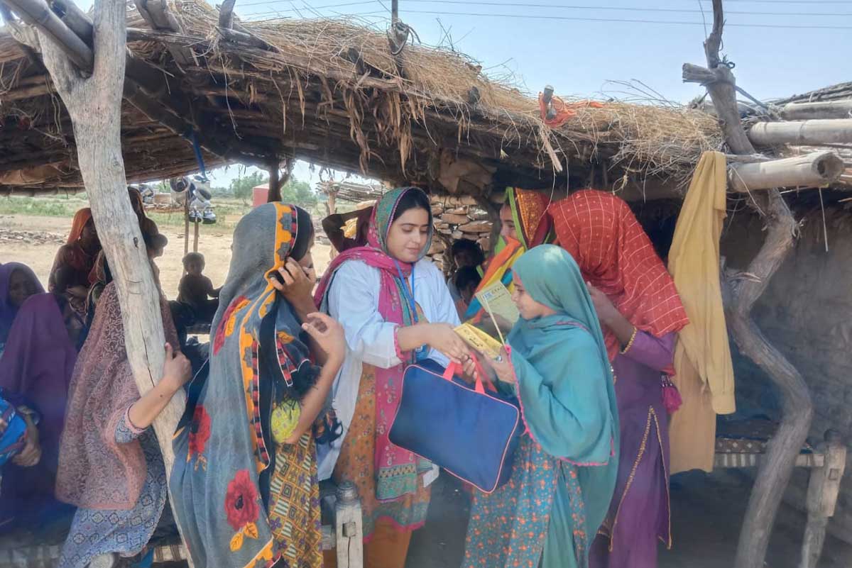 Team members in Jhpiego distributing WASH kits and awareness brochures among families displaced by flooding in 2022 in the remote and hard to reach coastal areas of Pakistan. Credit: Jhpiego.