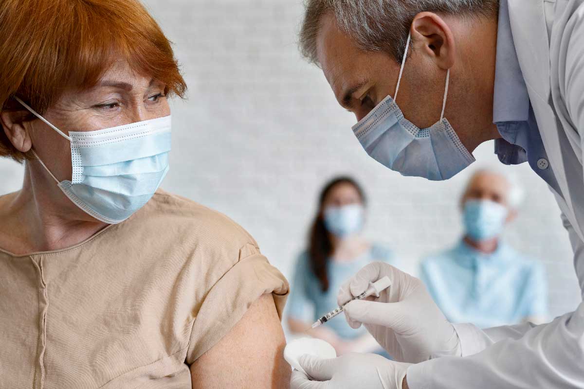 Woman getting vaccine shot by male medic. Credit: Freepik