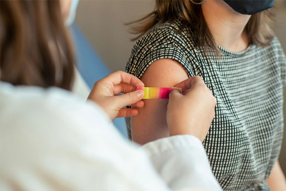 A plaster is applied to the injection site of a young woman after receiving a vaccination. Credit: Centers for Disease Control and Prevention (CDC)