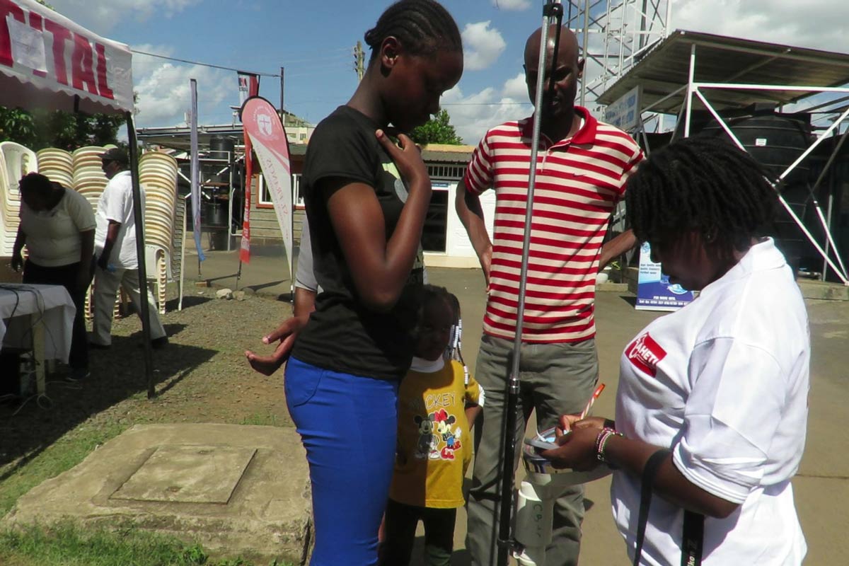 A young girl accompanied by her father to receive the HPV vaccine at an AHETI medical camp. Credit: Pauline Tom