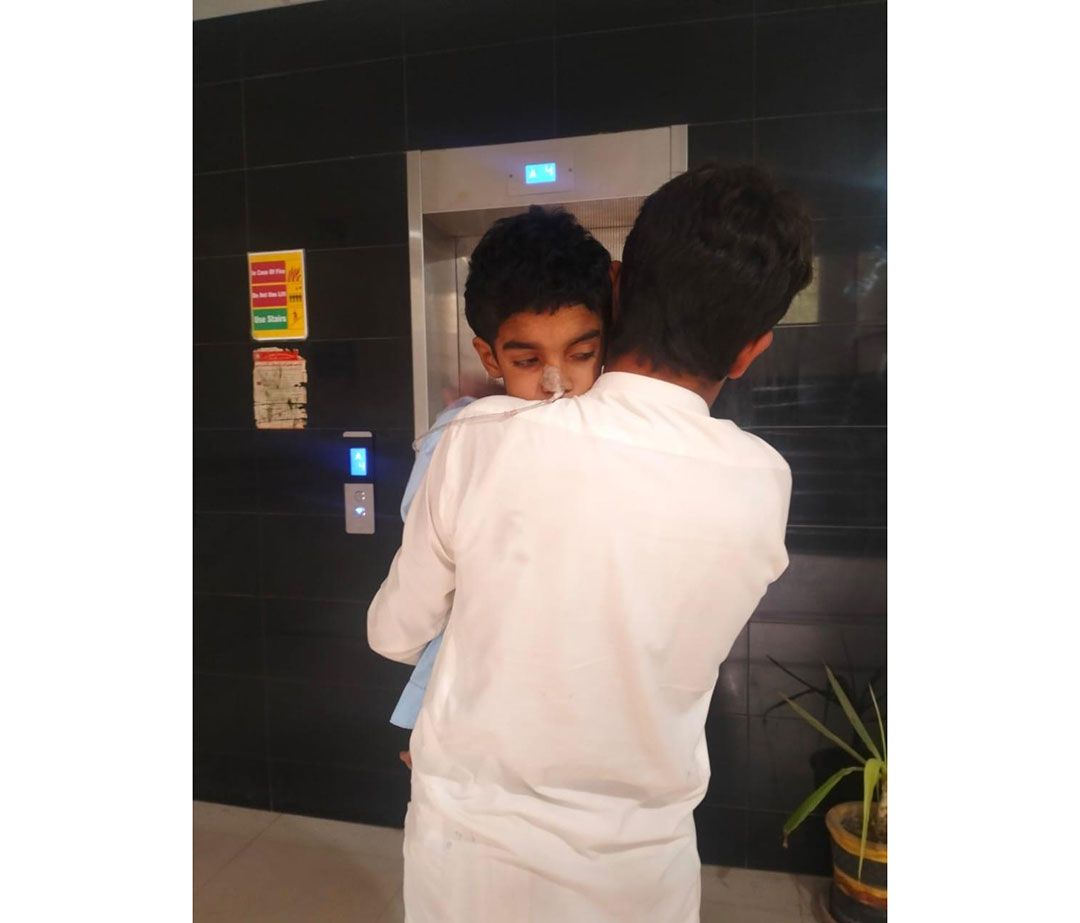 A boy carries his younger brother, who is suffering from Subacute Sclerosing Panencephalitis (SSPE), for examination by doctors at a medical camp held here on 6 September 2026. Credit: Adeel Saeed