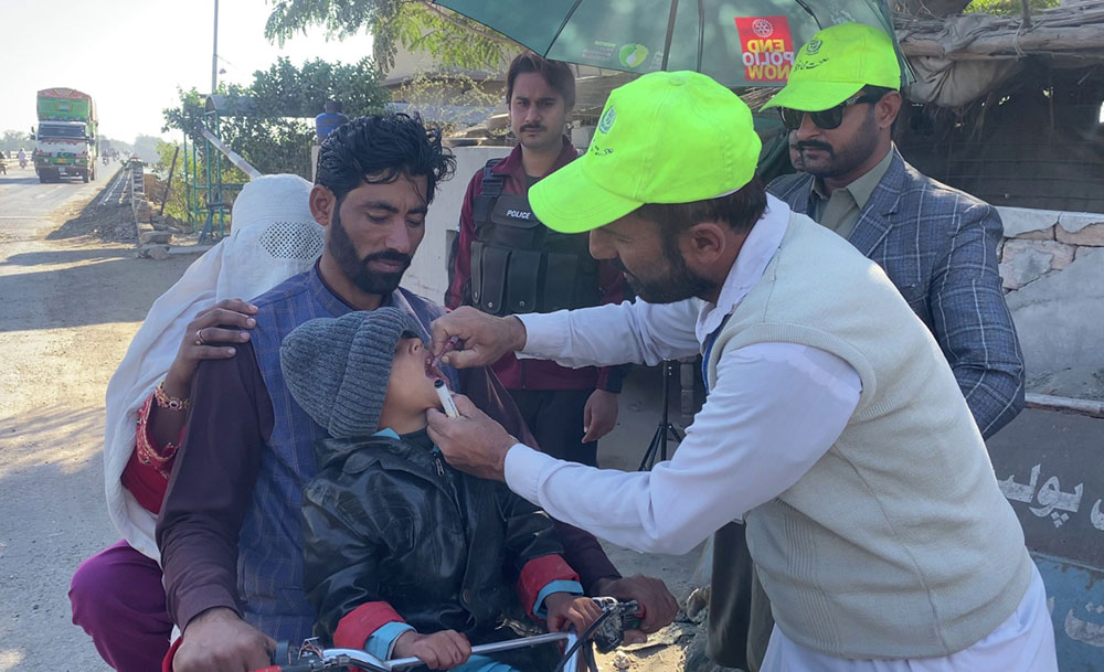 A team of polio vaccinators administering&nbsp;vaccine drops to a child from a migrant family at an interprovincial border crossing between Khyber Pakhtunkhwa and Punjab. Credit: EOC&nbsp;KP