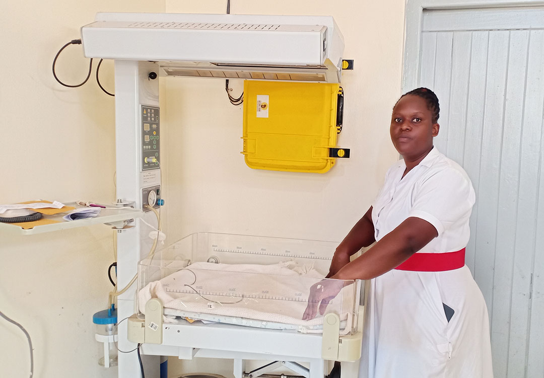 Midwife Betty Nakazibwe shows off a baby warmer that uses uninterrupted solar power. Credit: John Musenze