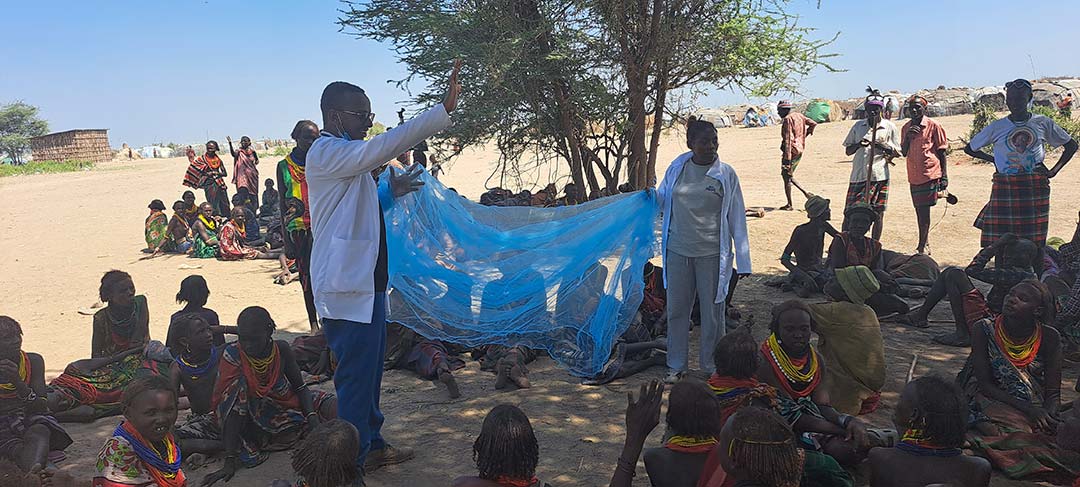 Dr Lisanwork Honsebo and a volunteer demonstrate how to use a mosquito net. Credit: READIO Ethiopia