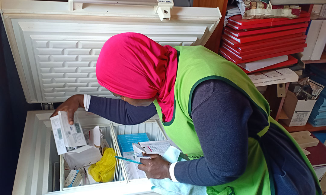 Dr Mastula Namagembe checks some of the vaccines kept in a vaccine fridge connected to the solar grid. Credit: John Musenze