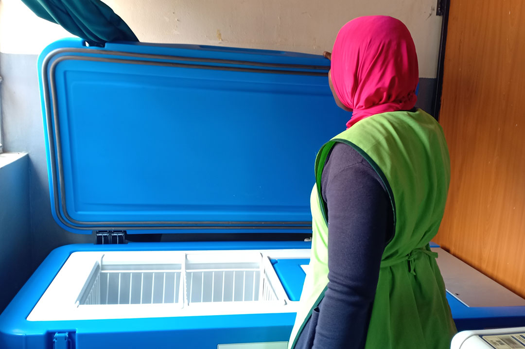 Clinical officer Dr Mastula Namagembe with the solar fridge installed alongside the solar power system Credit: John Musenze