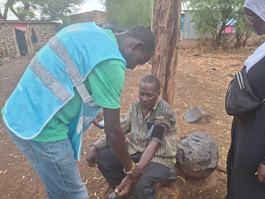 Samuel Ekiru treats Joseph Ewoi, a resident of Kambi Turkana, outside his home. Credit: Victor Moturi