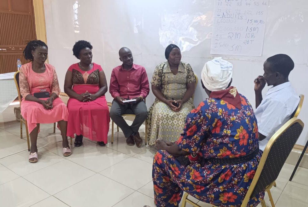 Kelvin Omega in a maroon shirt with other CHPs listening to two deaf patients. Photo by Kelvin