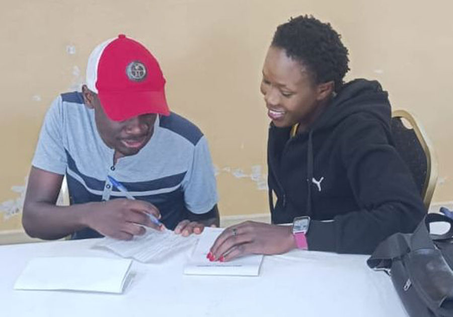 Kelvin Omega assisting his fellow CHP to interpret sign language symbols. Photo by Kelvin Kiliru Omega