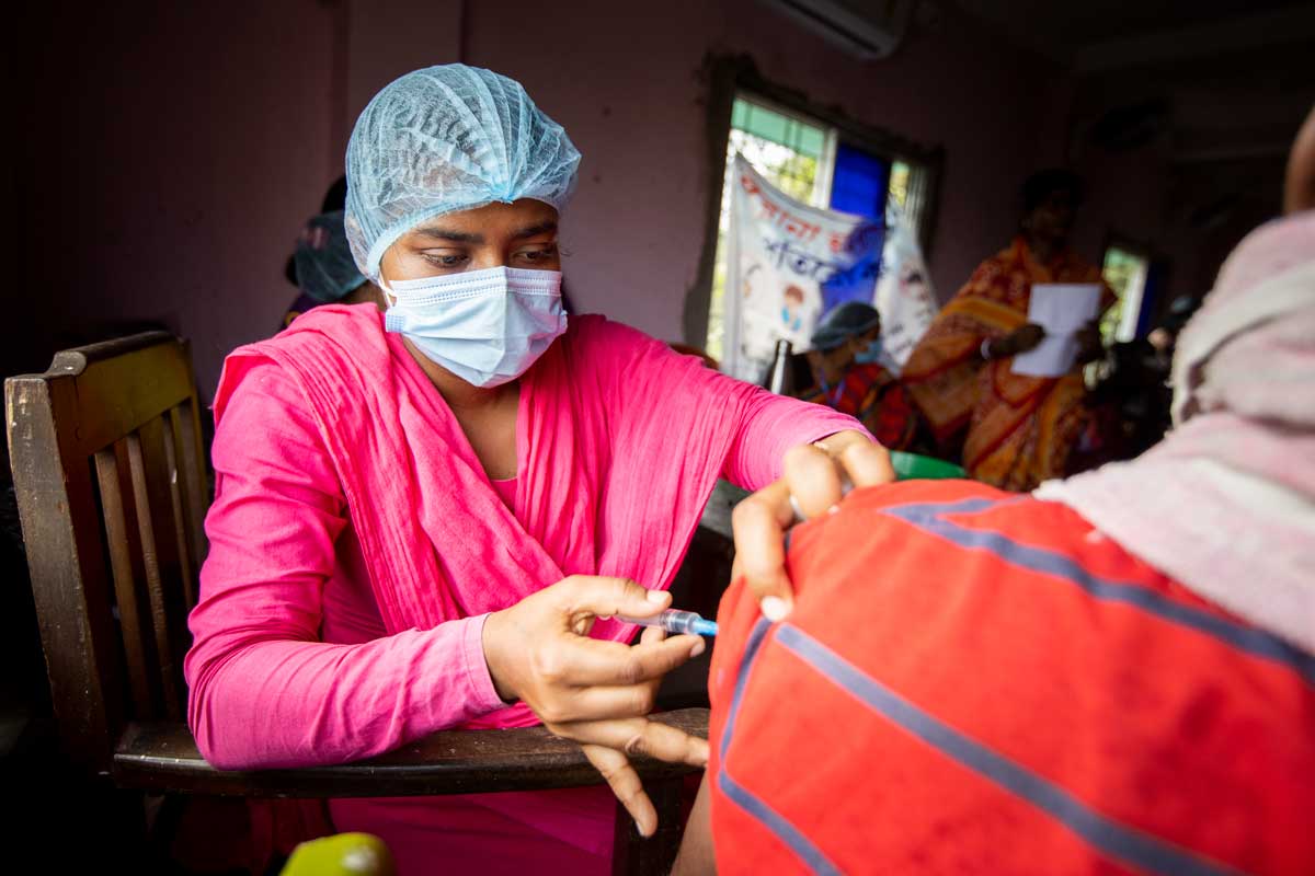 A female health worker administering a COVID-19 vaccine in India. Credit: Gavi/2022/Benedikt v.Loebell.