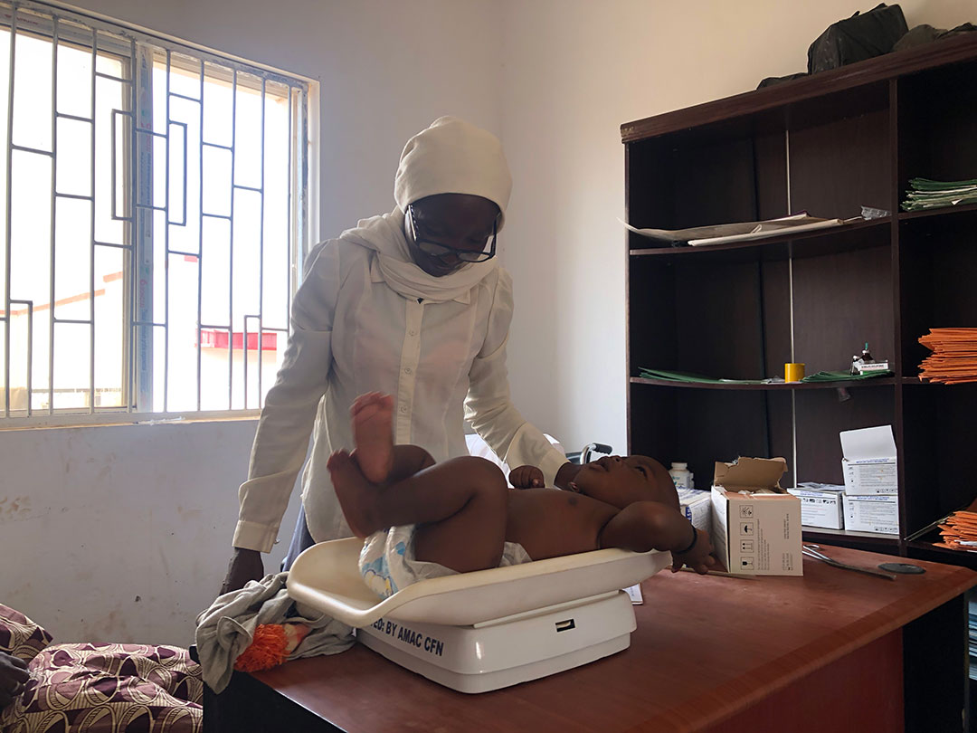 Rahila Yusuf checking the weight of Sarah Jacob's child. Credit: Ekpali Saint