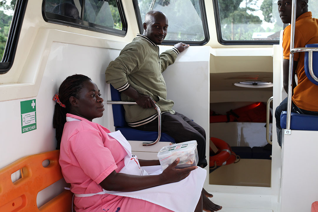 Ruth Gokyalya (in pink) aboard the boat, with Rebbecca Nabiryo lying on the bed, as two co-captains prepare to set off on the 25-minutes journey to the hospital on the mainland. Credit: John Musenze