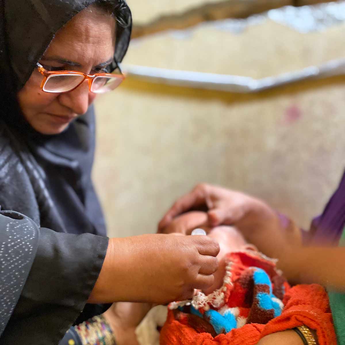 A community health worker (Aapi) administering vaccine to an infant in Dhoke Hassu Rawalpindi, Pakistan Picture Credits: Sumaiyah Hasan