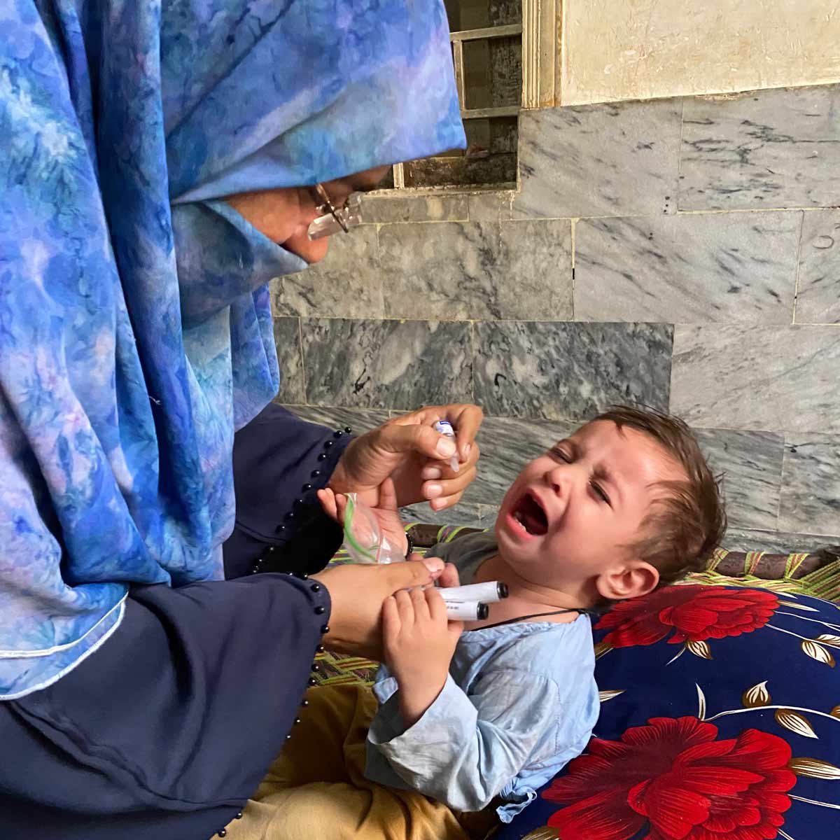 A community health worker (Aapi) administering vaccine to a child in Dhoke Hassu Rawalpindi, Pakistan. Credit: Sumaiyah Hasan.