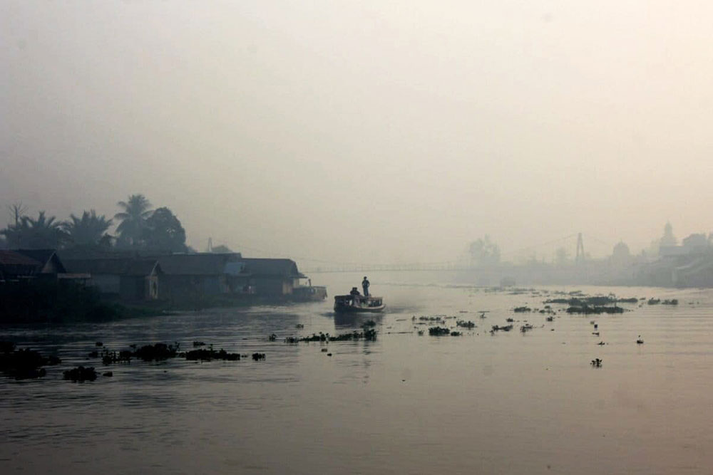 Haze from forest and land fires blankets the Lulut River area in Banjarmasin. Image by Riyad Dafhi Rizki/Mongabay Indonesia.