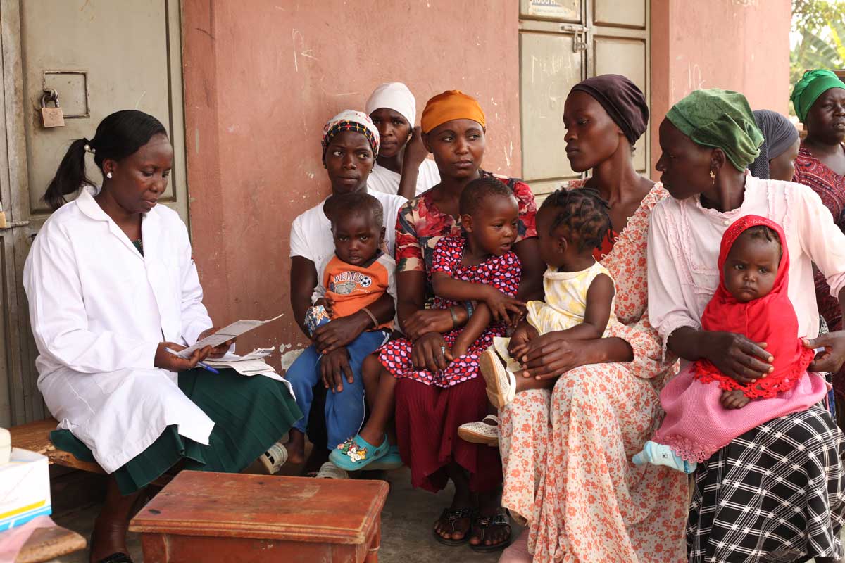 A nurse listening attending to mothers during an outreach. Credit: John Musenze